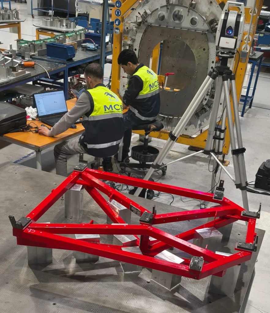 Équipe MCE mesurant une structure mécano-soudée au laser tracker